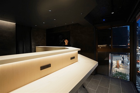 無垢のカウンターが 光に浮かぶ立喰鮨店